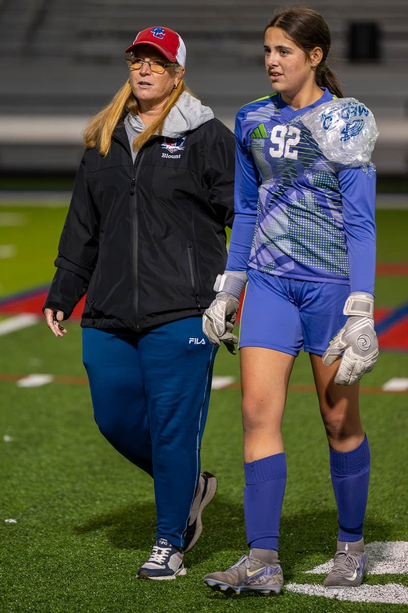 Coach Erin Blount walking with a player after a match